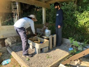 くぬぎの森自然遊び広場＆山の暮らし学校　井戸から水を手押しポンプで汲み、鍋を洗っているところ