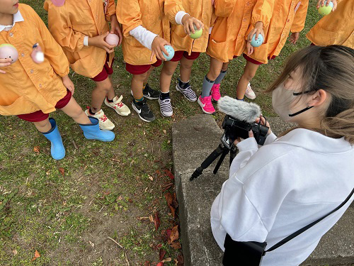 地域とアートプロジェクト実行委員会　完成したカプセルを振るところを動画で撮影する