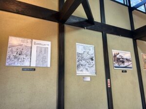 くらすむ滋賀の活動のようす画像　ほっこり庵の壁の、めがわ田楽の歴史を示すパネル