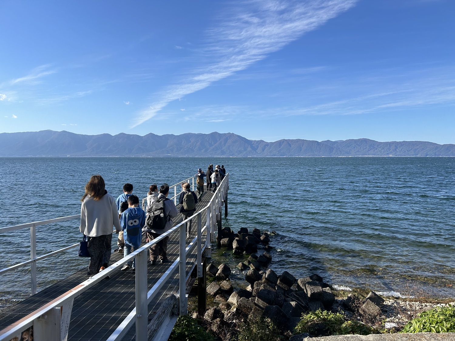 翔んでびわ湖の「大人のエコスクール」参加者の皆さんが、沖島を歩いてめぐる中で、びわ湖に突き出した桟橋まで出ていっているところ。