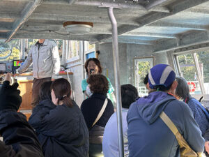 翔んでびわ湖の「大人のエコスクール」。チャーター船の中で説明するメンバー。