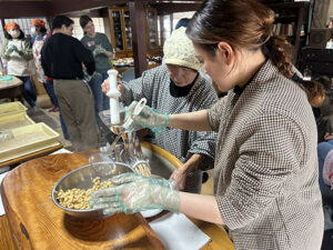 食養サークル　朝晴れ　活動のようす画像　ミンサーでゆで大豆をつぶす作業