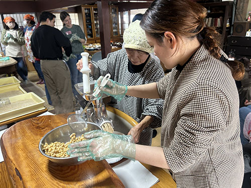 食養サークル 朝晴れ 活動のようす画像 ミンサーでゆで大豆をつぶす作業